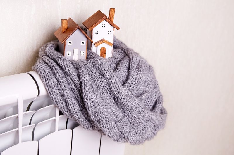 Игрушечные деревянные домики на батарее.