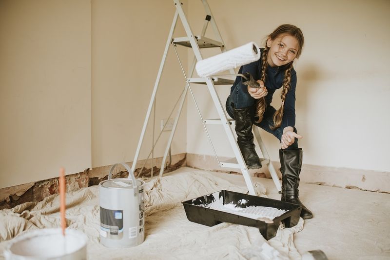 Девочка помогает перекрашивать комнату.