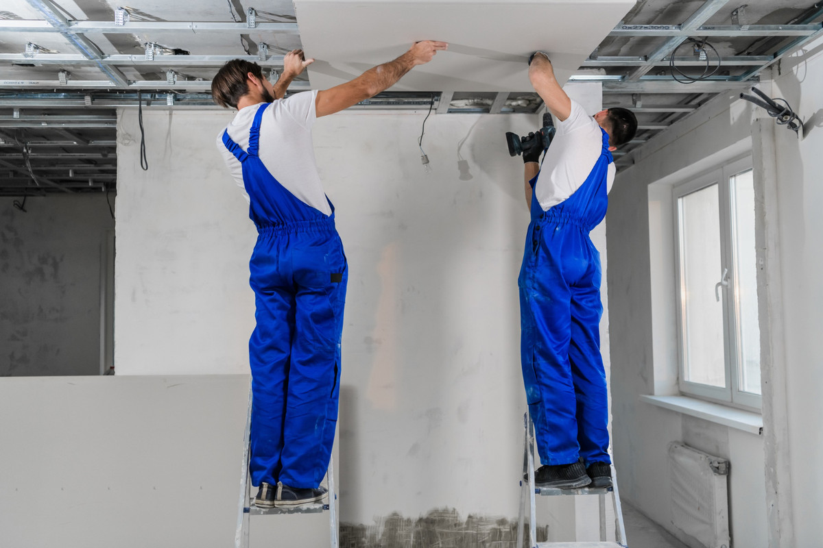 Двое мужчин делают потолок.